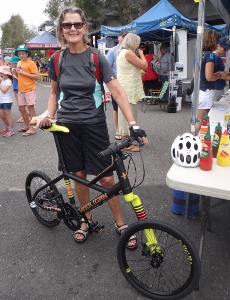 Mature female rider with small-wheeled bike at a community event
